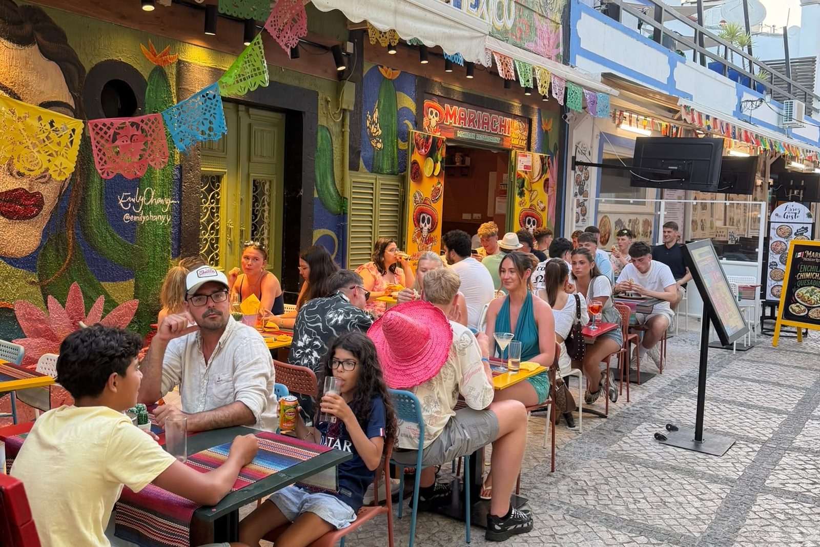 Mariachi's painted shopfront with the yellow skull sign and tables on the cobbled Old Town street